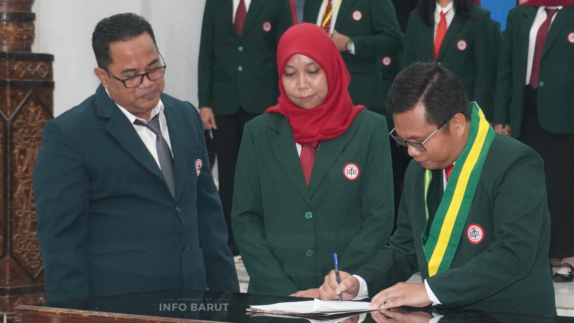 Ketua IDI Cabang Barito Utara masa bakti 2025–2028, dr. Riahdo J. Saragih, Sp.PD-KGH, (kanan) saat menandatangani berita acara pelantikan pengurus IDI Cabang Barito Utara disaksikan perwakilan Ketua IDI Wilayah Kalimantan Tengah, dr. Dadang Baskoro Nugroho, Sp.PD, FINASIM, (kiri) dan Ketua IDI Cabang Barito Utara periode 2022–2025, dr. Hj. Wahidah Asurawati, (tengah) di GPU Balai Antang, Muara Teweh, Minggu (24/5/2026). (Foto: Indra Tamara/infobarut.com).
