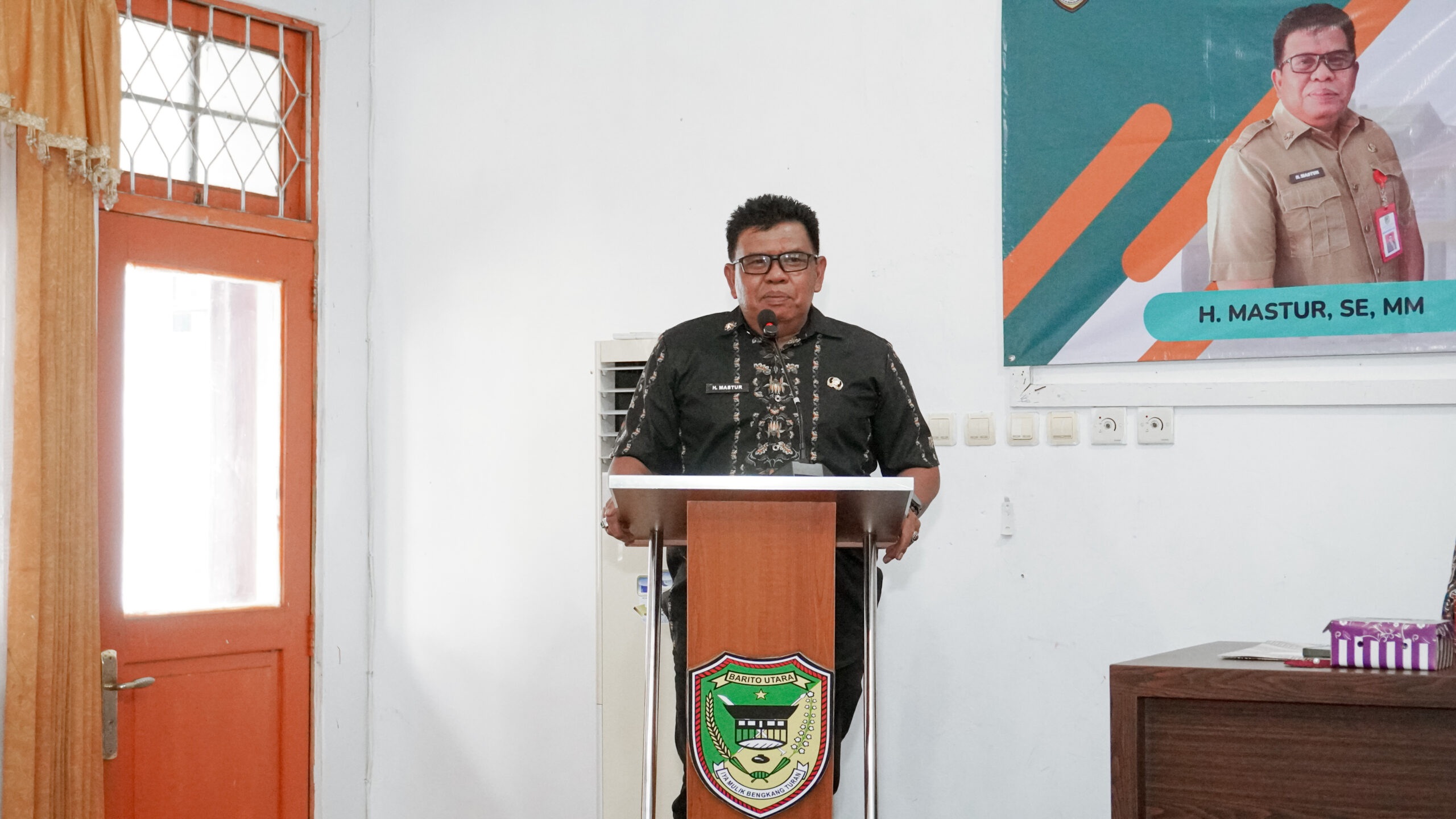H. Mastur, S.E., M.M menyampaikan sambutan dalam kegiatan serah terima jabatan Kepala Disnakertranskop UKM Kabupaten Barito Utara di Aula Disnakertranskop UKM Barito Utara, Jumat, 8 Mei 2026. (Dok. InfoBarut.com)