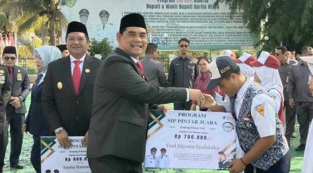 Bupati Barito Utara menyerahkan bantuan SIP Pintar Juara kepada pelajar berprestasi